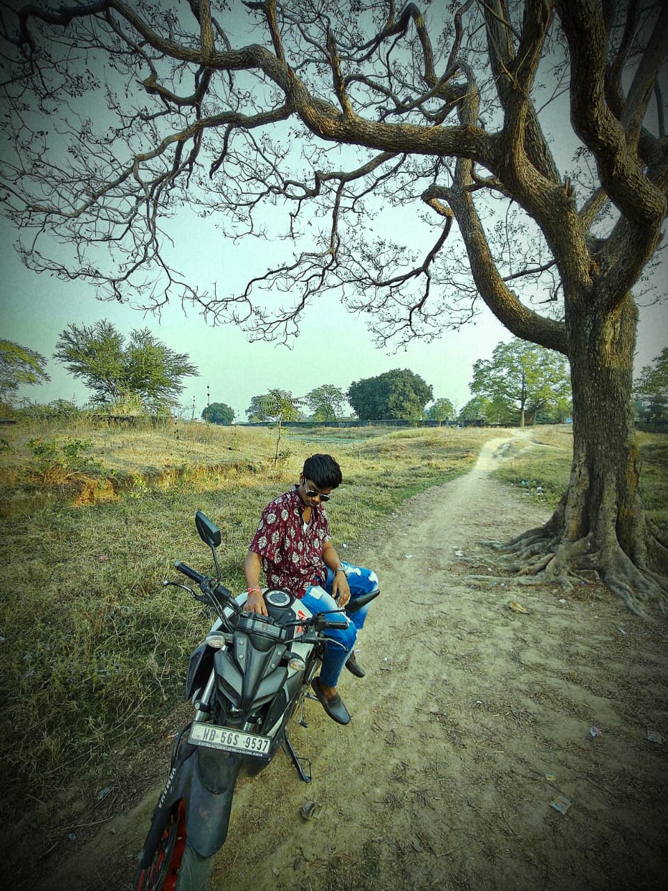 Suman standing in open field near hills